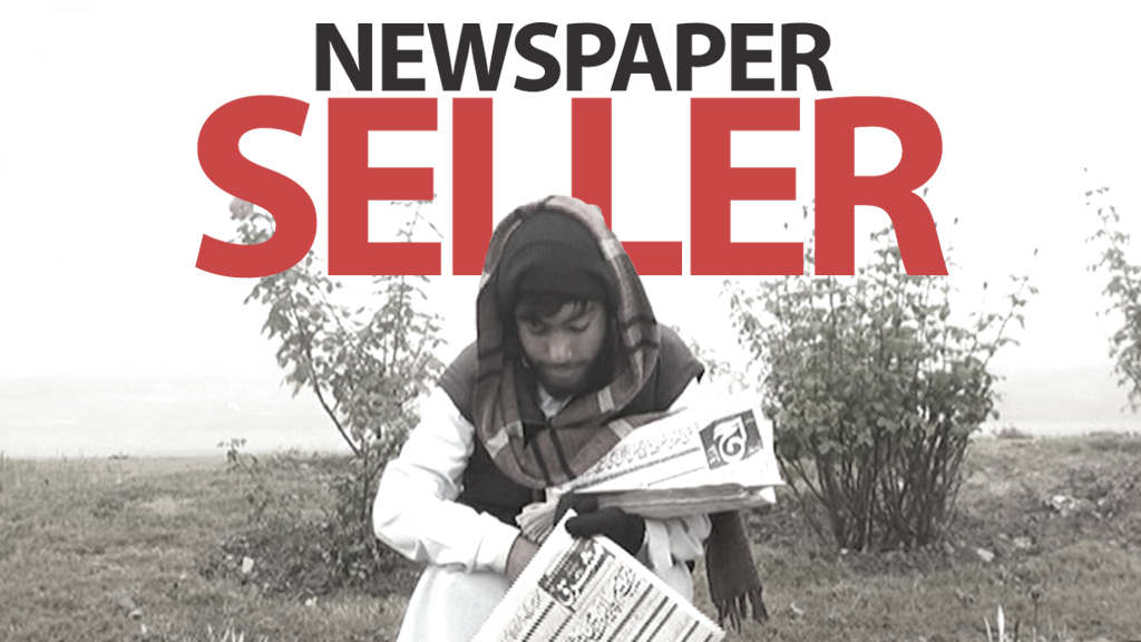 A young boy sells newspaper despite freezing weather in Peshawar