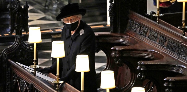 Queen Elizabeth stands alone as Philip is laid to rest; William and Harry talk