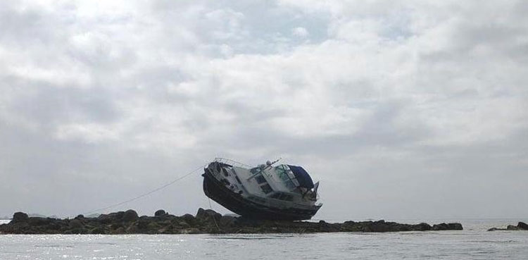 Motor boat left perched on rocks after running aground