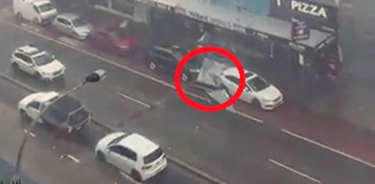 Watch: Narrow escape for passing car as storm blows off metal roof
