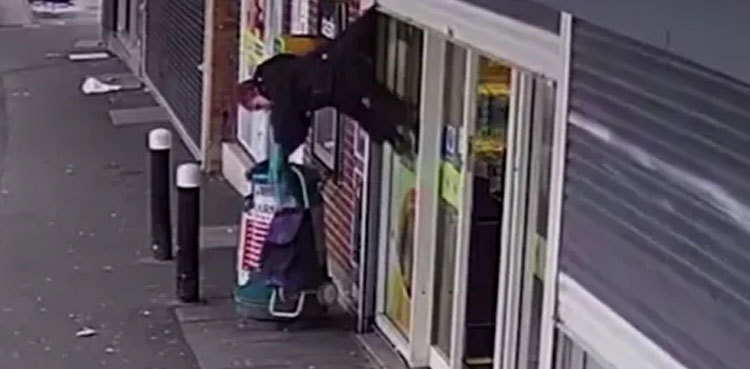 Watch: Woman left dangling after coat gets stuck on shutter