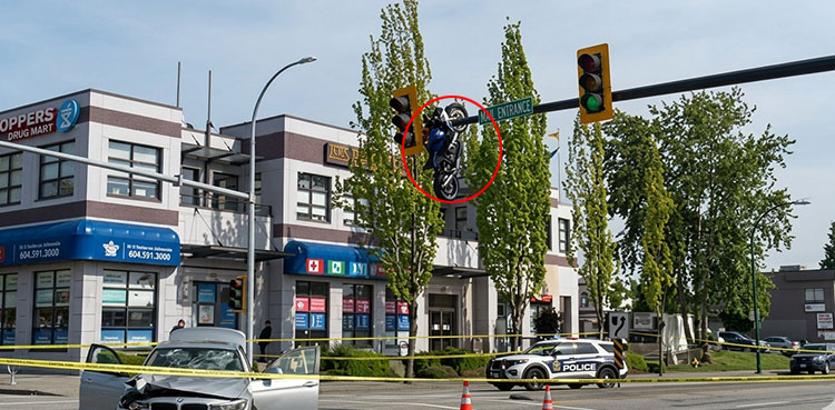 Viral video shows motorcycle dangling from traffic signal pole after shocking crash